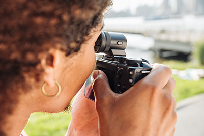  A female holding the Canon EOS M6 Mark II and framing through a EVF  